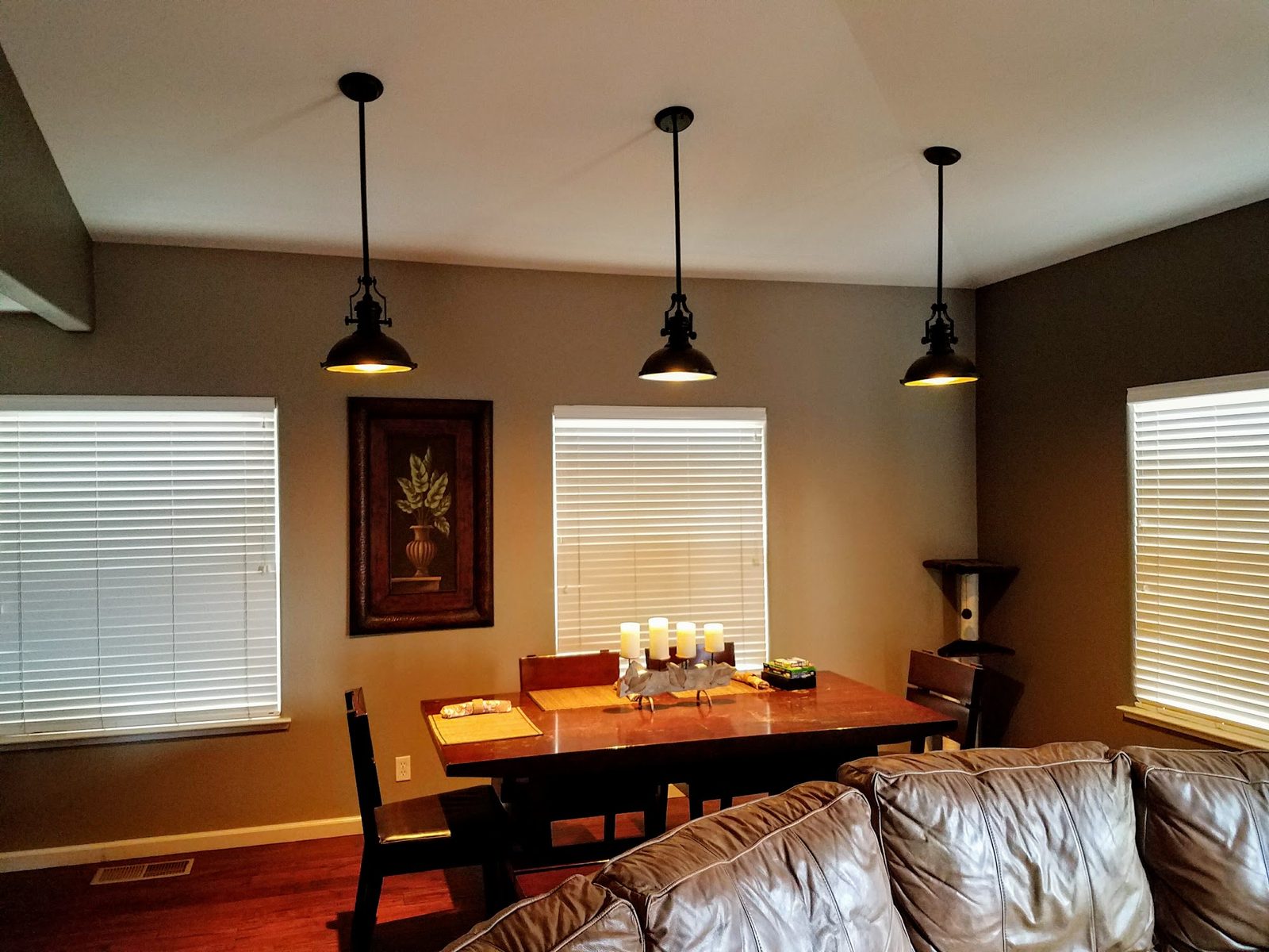 Trio of industrial pendant lights installed over a dining table